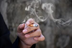 Woman ruining her dental health by smoking a cigarette.