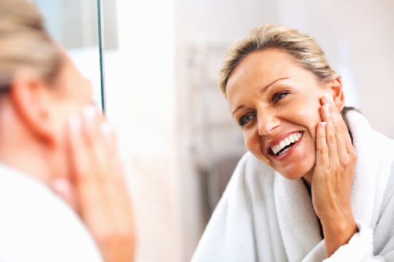 Happy mature woman admiring herself in the mirror