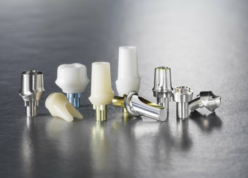 image of several dental implant abutements and restorations on a table